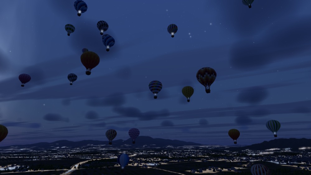 Balloons glowing from their burners over a town at dusk under the first stars
