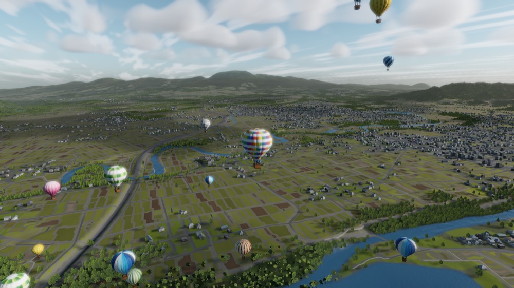 Balloons scattered across a wide river plain of fields and towns in the morning