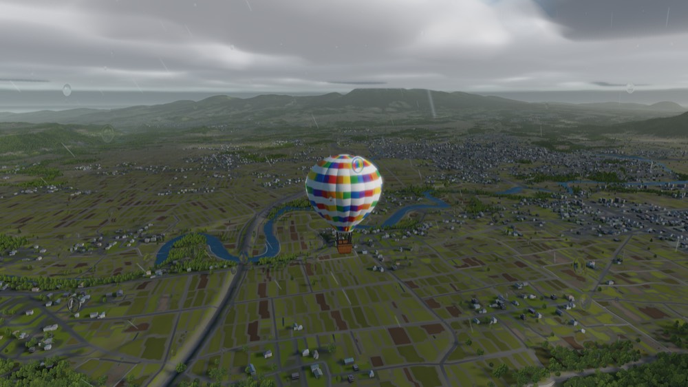 A balloon under a low overcast with rain falling over the fields