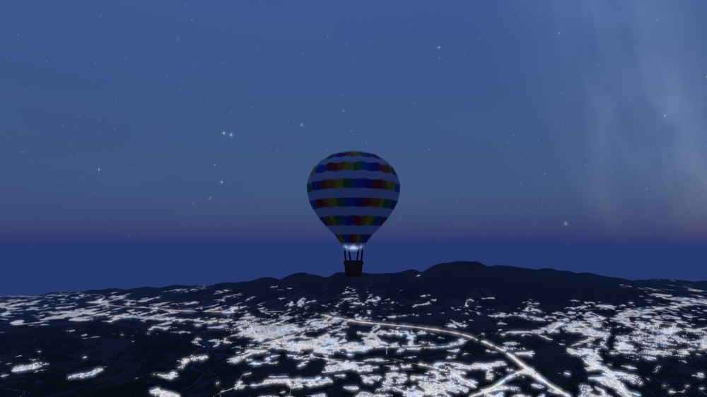 A balloon silhouetted against a star field above a distant town