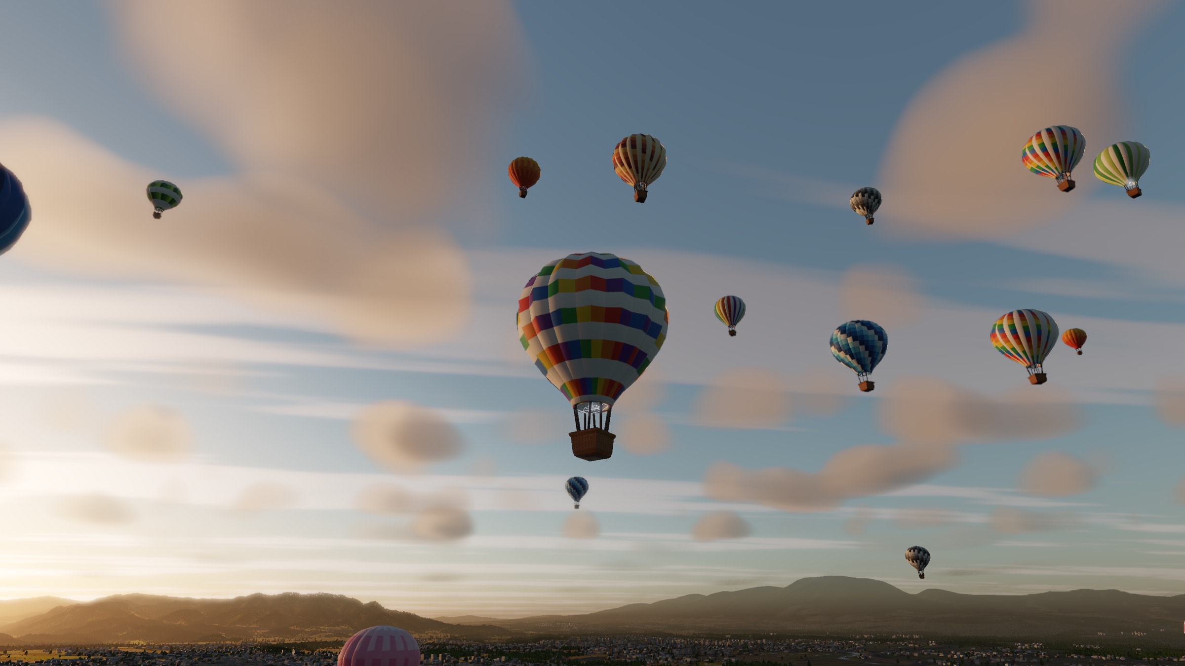 Dozens of hot air balloons rising together over a wide valley at sunrise