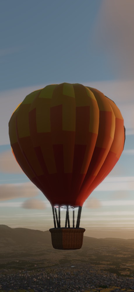 An orange and gold balloon over hills in the first light of day
