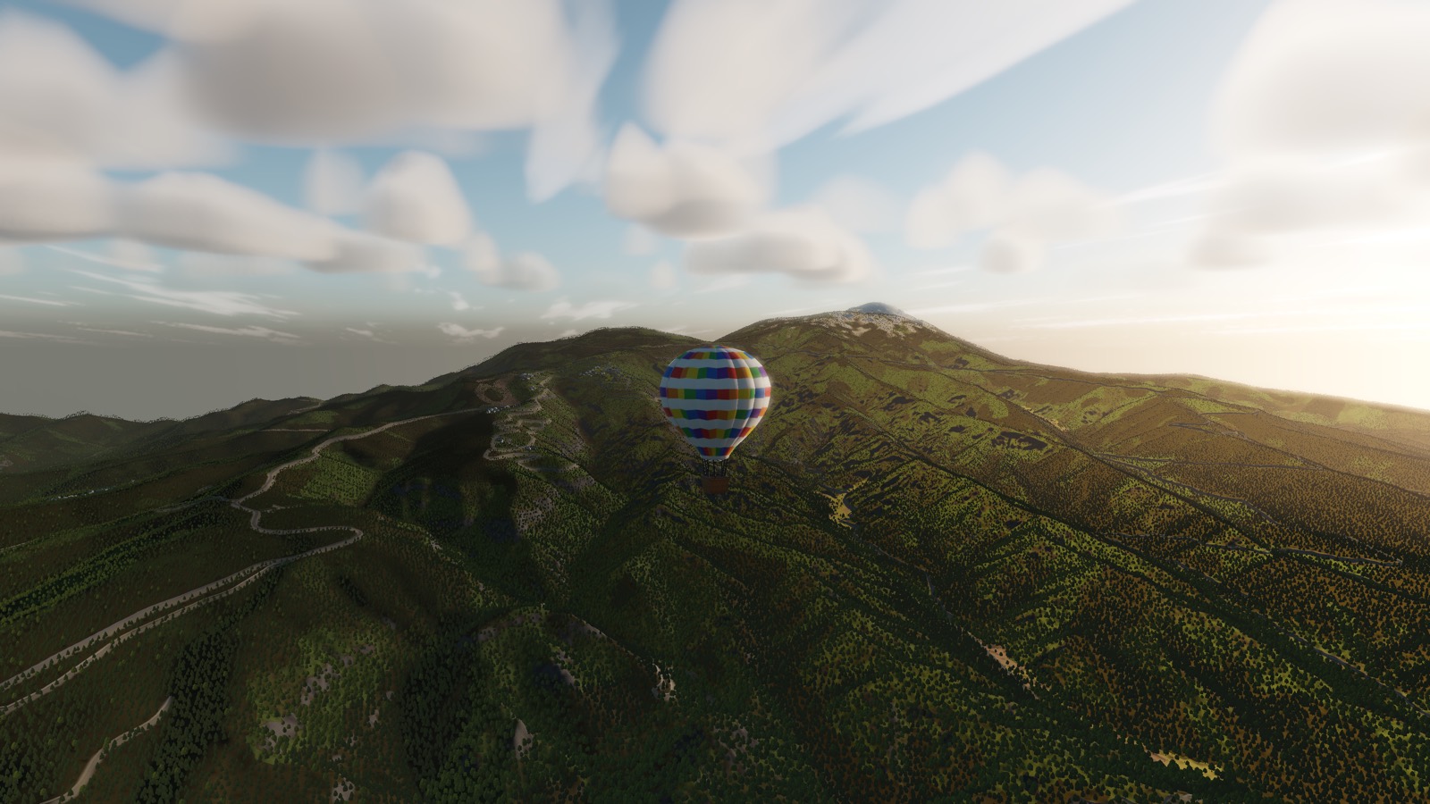 A balloon crossing a green ridge in golden light with a distant peak beyond