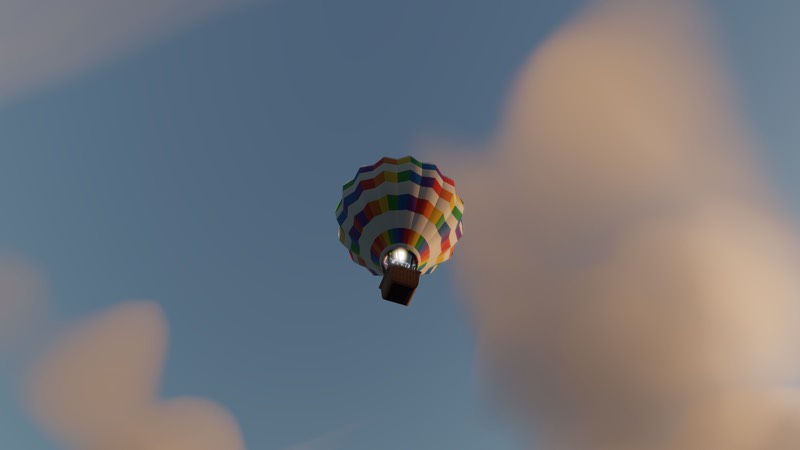 A brightly striped balloon seen from below, high against a blue sky with cloud